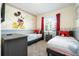 Mickey Mouse-themed bedroom with twin beds and red curtains at 3151 Paradox Cir # 101, Kissimmee, FL 34746