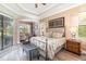 Luxurious main bedroom with a king-size bed and private access to patio at 25822 Feather Ridge Ln, Sorrento, FL 32776