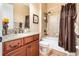 Bathroom with granite countertop, shower/tub combo, and brown accents at 25822 Feather Ridge Ln, Sorrento, FL 32776