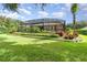 Landscaped backyard with a screened enclosure and lush greenery at 25822 Feather Ridge Ln, Sorrento, FL 32776