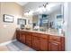 Double vanity bathroom with granite countertops and large mirror at 25822 Feather Ridge Ln, Sorrento, FL 32776