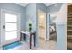 Bright entryway with light blue walls, tile floors, and a view of the staircase and bathroom at 740 Pebble Beach Dr, Davenport, FL 33896