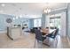 Open concept dining area with a wood table, gray chairs, and kitchen island visible at 740 Pebble Beach Dr, Davenport, FL 33896