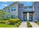 Modern two-story townhome with gray siding, stone accents, and blue doors at 740 Pebble Beach Dr, Davenport, FL 33896