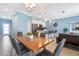 Bright dining area with a wood table and gray chairs, adjacent to the kitchen and living room at 740 Pebble Beach Dr, Davenport, FL 33896