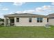 Covered patio and grassy backyard with a view of neighboring homes at 12965 Trovita Dr, Grand Island, FL 32735