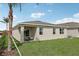 Covered patio and grassy backyard with a view of palm trees at 12965 Trovita Dr, Grand Island, FL 32735
