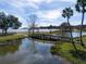 Scenic park with a wooden footbridge over a calm lake, surrounded by lush greenery at 12965 Trovita Dr, Grand Island, FL 32735