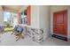 Inviting front porch with red door and stone accents at 12965 Trovita Dr, Grand Island, FL 32735