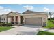 House exterior with a two-car garage and front porch at 12965 Trovita Dr, Grand Island, FL 32735