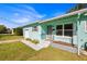 Light teal house with a well-manicured lawn and a gray walkway leading to the entrance at 2811 Vine St, Orlando, FL 32806