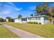 Ranch style home with light teal exterior, landscaping, and sidewalk at 2811 Vine St, Orlando, FL 32806