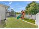 Backyard view showcasing a playset and screened patio at 365 Cimarron Ct, Kissimmee, FL 34759