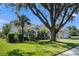 House exterior showcasing landscaping and a large oak tree in the front yard at 14310 Lord Barclay Dr, Orlando, FL 32837