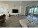 Bright living room with hardwood floors, large TV, and access to a balcony at 3384 Corona Village Way # 108, Orlando, FL 32835