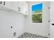 Laundry room with white cabinets, patterned floor, and window at 131 E Grant, Orlando, FL 32806