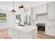 Modern kitchen with white cabinets, quartz countertops, and stainless steel appliances at 131 E Grant, Orlando, FL 32806