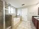 Bathroom with soaking tub, walk-in shower, and dark wood cabinets at 14501 Grove Resort Ave # 1507, Winter Garden, FL 34787