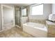 Spa-like bathroom with soaking tub, walk-in shower, and tile flooring at 14501 Grove Resort Ave # 1507, Winter Garden, FL 34787