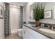 Main bathroom with double vanity, shower, and granite countertop at 1502 Isleta Loop, Kissimmee, FL 34741