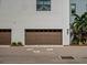 Modern garage with wood door and landscaping at 1818 Mondrian Cir, Winter Park, FL 32789