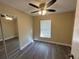 Bedroom with ceiling fan, mirrored closet, and wood-look floors at 641 Bayport Dr, Kissimmee, FL 34758