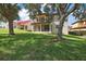 House with backyard, large trees and green lawn at 212 Crestrun Loop, Leesburg, FL 34748