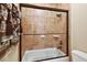 Clean bathroom with a shower/tub combo and glass sliding doors at 212 Crestrun Loop, Leesburg, FL 34748
