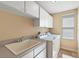 Bright laundry room with washer, dryer, and utility sink at 212 Crestrun Loop, Leesburg, FL 34748
