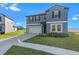 Two-story house with gray siding, landscaping and driveway at 3519 Lounging Wren Ln, Bartow, FL 33830
