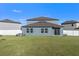 Large backyard with grassy area and white vinyl fence at 3519 Lounging Wren Ln, Bartow, FL 33830