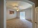 Main bedroom with carpet flooring, ceiling fan and access to backyard at 24023 Robinwood St, Leesburg, FL 34748