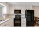 Modern kitchen with white cabinets, granite counters, and black appliances at 1000 Lake Of The Woods Blvd # A204, Fern Park, FL 32730
