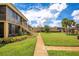 Exterior view of the condo building with lush landscaping at 1000 Lake Of The Woods Blvd # A204, Fern Park, FL 32730