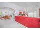 Open concept living and dining area with red sectional sofa and dining table at 3070 Silver Fin Way, Kissimmee, FL 34746