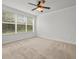 Carpeted bedroom with ceiling fan and large window at 8362 Bella Tierra Ct, Davenport, FL 33896