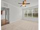 Carpeted main bedroom with ceiling fan and large window at 8362 Bella Tierra Ct, Davenport, FL 33896