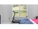 Bedroom with treadmill and large window overlooking backyard at 205 Bella Verano Way, Davenport, FL 33897