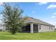 Rear view of house with screened porch and landscaping at 205 Bella Verano Way, Davenport, FL 33897