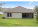Rear view of house with screened porch and lawn at 205 Bella Verano Way, Davenport, FL 33897