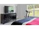 Bedroom with large TV, dresser, and treadmill near window at 205 Bella Verano Way, Davenport, FL 33897