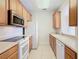 View of kitchen with wood cabinets, appliances, and tile floor at 8298 Portofino Dr # 202, Davenport, FL 33896