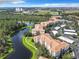 Aerial view of Bella Trae community featuring apartment buildings, a lake, and parking at 8298 Portofino Dr # 202, Davenport, FL 33896