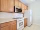 Kitchen features wood cabinets, stainless steel appliances, and tile flooring at 8298 Portofino Dr # 202, Davenport, FL 33896
