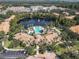 Resort-style pool at Bella Trae, surrounded by lush landscaping and a lake at 8298 Portofino Dr # 202, Davenport, FL 33896