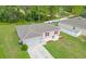 Aerial view of a single-story house with red shutters, a two-car garage, and a well-manicured lawn at 319 St Cloud Rd, Poinciana, FL 34759