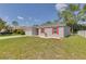 Gray house with red shutters, two-car garage, and grassy yard at 319 St Cloud Rd, Poinciana, FL 34759