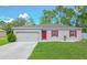 Single-story home with gray siding, red shutters, and a two-car garage at 319 St Cloud Rd, Poinciana, FL 34759