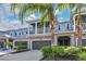 Two-story townhome with attached garage, balcony, and lush landscaping at 593 Lake Wildmere Cv, Longwood, FL 32750
