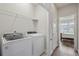 Laundry room with Whirlpool washer and dryer, and overhead shelving at 594 Piazza Pt, Oviedo, FL 32765